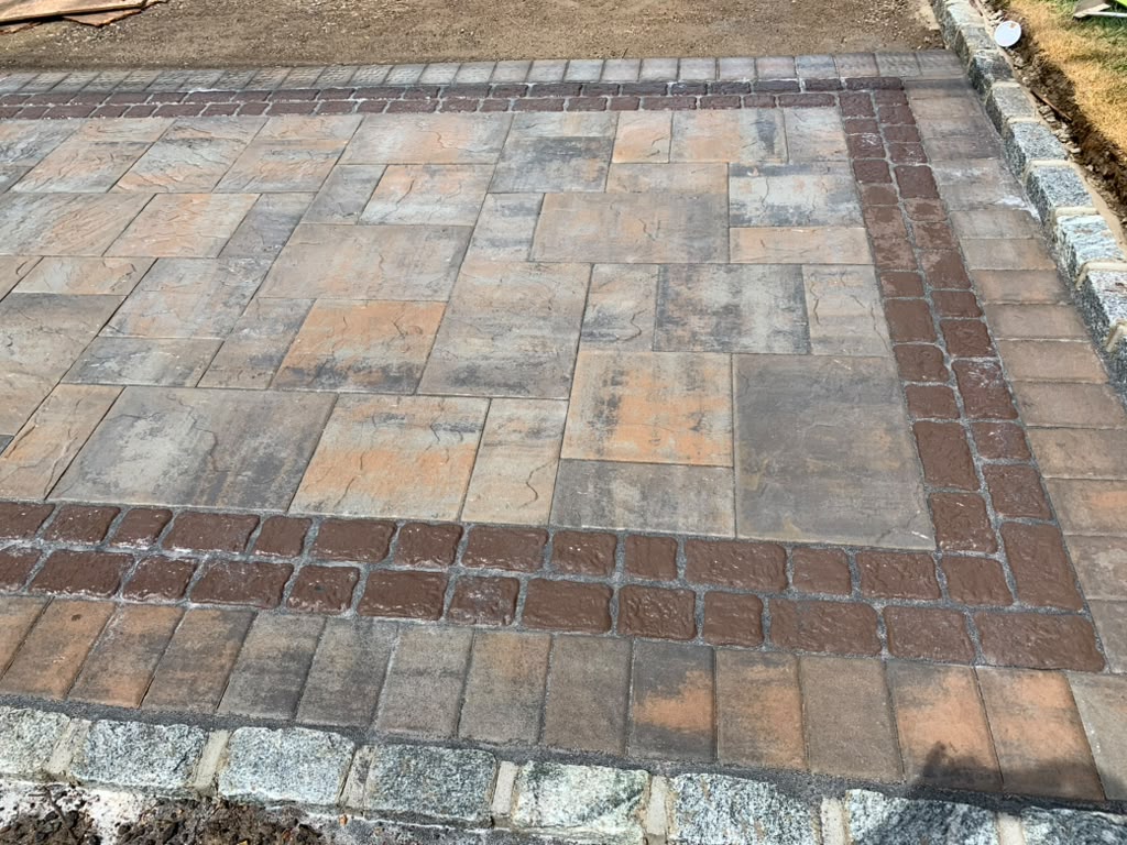 Earth-tone paver patio with cobblestone border — Ronkonkoma, NY
